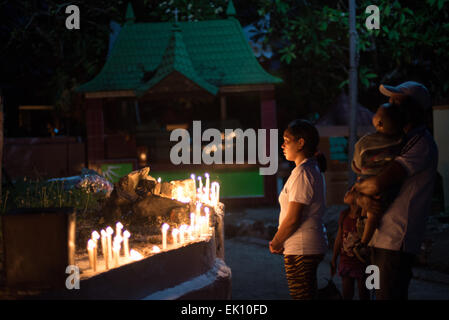 Une famille à prier dans le cimetière catholique romain Larantuka, l'île de Flores, en Indonésie, après la messe, cérémonie à l'église cathédrale. Des milliers de personnes, y compris ceux d'autres villes et pays, assister à toute une semaine pour célébrer les cérémonies de la Semaine Sainte dans la petite ville de Larantuka, une des villes les plus influentes en Indonésie en termes de tradition catholique romaine. Banque D'Images