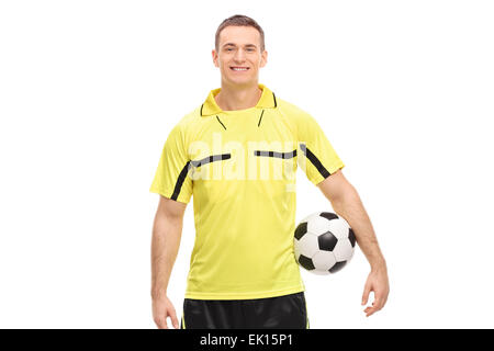 Arbitre de football masculin dans un maillot jaune tenant une balle et à la caméra à isolé sur fond blanc Banque D'Images