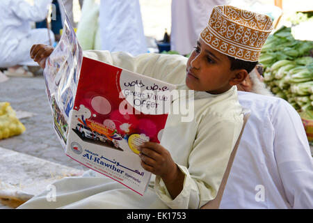 Boy reading supermarché, publicité Sinaw, Oman Banque D'Images