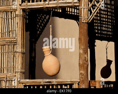 La poterie cruche d'eau suspendues dans des abris à bois fenêtre grillagées, Fort Nizwa Nizwa, Oman, Banque D'Images