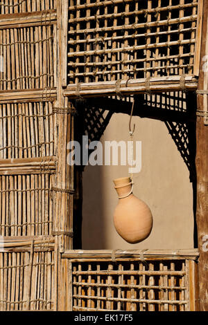 La poterie cruche d'eau suspendues dans des abris à bois fenêtre grillagées, Fort Nizwa Nizwa, Oman, Banque D'Images