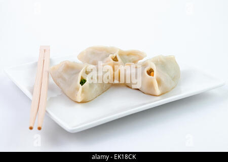 Raviolis chinois sur plaque blanche sur fond blanc Banque D'Images