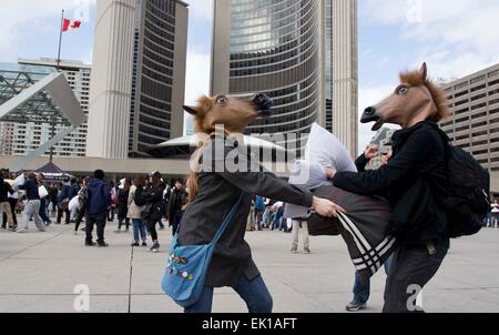 Toronto, Canada. 4ème apr 2015. Des gens portant des masques de tête de cheval prendre part à la guerre d'oreillers 2015 événement au Nathan Phillips Square de Toronto, Canada, le 4 avril 2015. L'International Pillow Fight Day 2015 événement s dans les villes à travers le monde le samedi. © Zou Zheng/Xinhua/Alamy Live News Banque D'Images