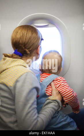 La mère et l'enfant de fils à bord de l'avion Banque D'Images