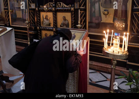 Un pèlerin russe orthodoxe s'embrasser une icône religieuse à l'église de Saint Alexandre Nevsky dans le quartier chrétien de la vieille ville de Jérusalem Israël Banque D'Images