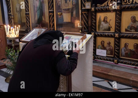 Un pèlerin russe orthodoxe s'embrasser une icône religieuse à l'église de Saint Alexandre Nevsky dans le quartier chrétien de la vieille ville de Jérusalem Israël Banque D'Images