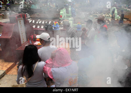 Palembang, Indonésie. 06Th avr, 2015. Une famille chinoise prier pendant Cheng Beng cérémonie. Cheng Beng, connu en Chine comme Qingming, est une fête traditionnelle qui marque de plus en hiver au printemps. Pendant ce temps, les familles visiter les tombes de leurs ancêtres pour se recueillir, faire des offrandes et prier pour une vie meilleure © Muhammad Raden/Pacific Press/Alamy Live News Banque D'Images