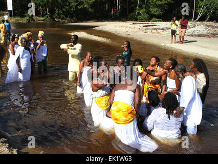 Les amateurs de l'Ile Ijosin Meji-Awon Otura Osun Shrine nettoyer dans une rivière et faire des offrandes d'Oshun. Banque D'Images