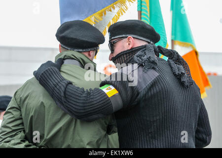 Belfast, en Irlande du Nord, Royaume-Uni. 5 avril, 2015. Un homme portant un uniforme paramilitaire noir, y compris des lunettes noires, écharpe et béret, parle à un membre de la partie couleur du parti socialiste républicain irlandais (étroitement affilié à l'Armée de libération nationale irlandaise interdits) Crédit : Stephen Barnes/Alamy Live News Banque D'Images