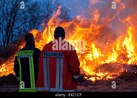 Pompiers observant Easter eve bonfire, Neetze, Basse-Saxe, Allemagne Banque D'Images