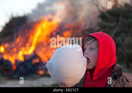 Jeune garçon mangeant candyfloss devant Easter eve bonfire, Neetze, Basse-Saxe, Allemagne Banque D'Images