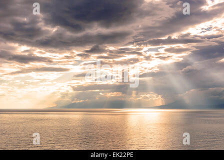 Coucher du soleil sur la côte, les rayons du soleil traversent les nuages Banque D'Images