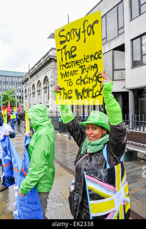 Belfast, Irlande du Nord. 15 juin 2013. Une femme occupe le haut d'une bannière qui dit "Désolé pour le dérangement. Nous essayons de changer le monde' à une manifestation anti-G8 organisé par le Congrès irlandais des syndicats (ICTU) Banque D'Images