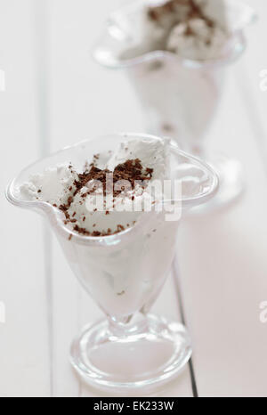 Verre de glace crème avec vermicelles de chocolat sur une table en bois Banque D'Images