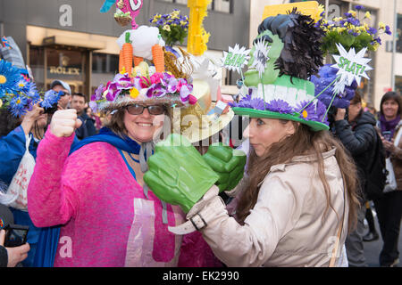 2 Deux femmes portant un bonnet à Pâques, des lunettes et des faux poings durant la parade de Pâques Bonnet sur la Cinquième Avenue à New York. Banque D'Images