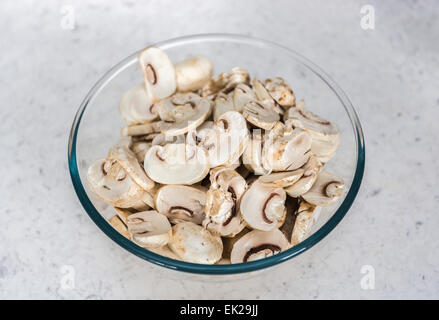 Ingrédients de cuisine Accueil - un verre ou bol en pyrex de matières non cuite, champignons de Paris tranchés préparé prêt à être utilisé en cuisine Banque D'Images