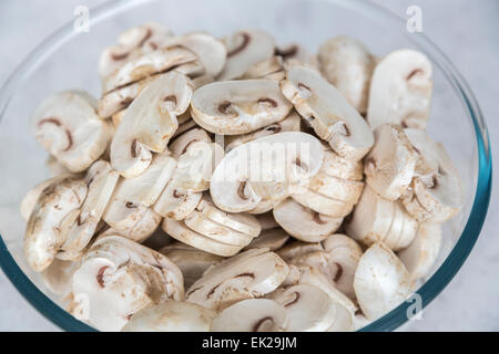 Ingrédients de cuisine Accueil - un verre ou bol en pyrex de matières non cuite, champignons de Paris tranchés préparé prêt à être utilisé en cuisine Banque D'Images