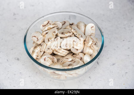 Ingrédients de cuisine Accueil - un verre ou bol en pyrex de matières non cuite, champignons de Paris tranchés préparé prêt à être utilisé en cuisine Banque D'Images