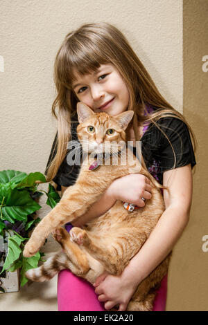 Sept ans, fille de câlins avec son chat Banque D'Images