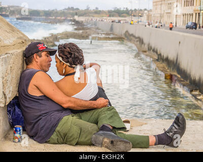 Deux amateurs d'âge moyen sur le Malecón cubains mur par le port de La Havane avec l'homme faisant la moue. Banque D'Images