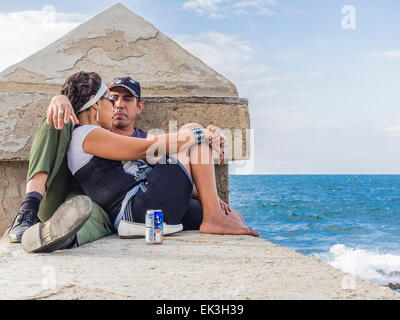 Deux amateurs d'âge moyen sur le Malecón cubains mur par le port de La Havane avec l'homme faisant la moue. Banque D'Images