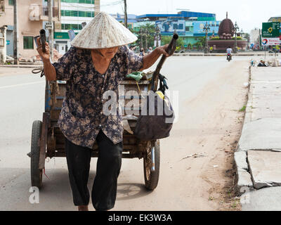 Vieille Femme tirant des panier dans la rue à Kampot, Cambodge, Asie Banque D'Images