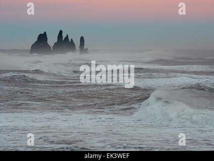 Les piles de la mer debout fier dans la lumière du soir et une mer autour de Vik, sur la côte sud de l'Islande Banque D'Images