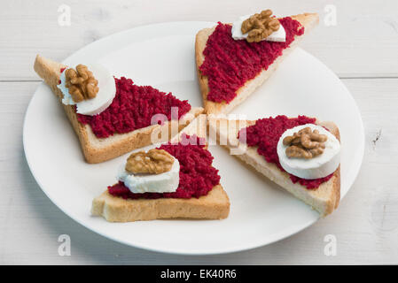 Ouvert sandwiches avec propagation de betterave rouge, le fromage de chèvre et noix Banque D'Images