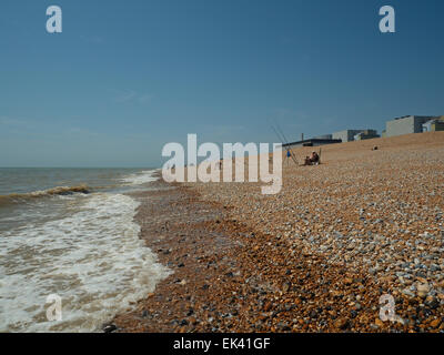 Les pêcheurs la pêche au large de la plage de galets à Dungerness avec centrale nucléaire de Dungeness en arrière-plan. Kent, Angleterre Banque D'Images