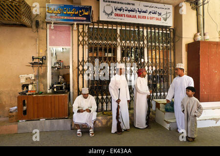 Les hommes et le garçon devant les boutiques dans le souk de Nizwa, Oman, Banque D'Images