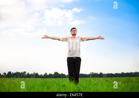 Jeune homme faisant du yoga in park Banque D'Images