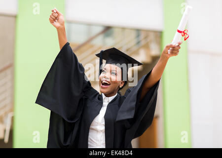 African American female graduate smiling standing in front of university building Banque D'Images