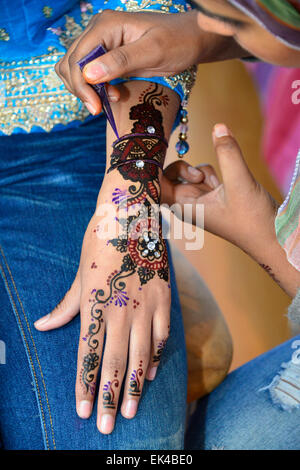 La mise en peinture au henné sur la main d'une jeune femme sur le point de s'engager à être mariés. Banque D'Images