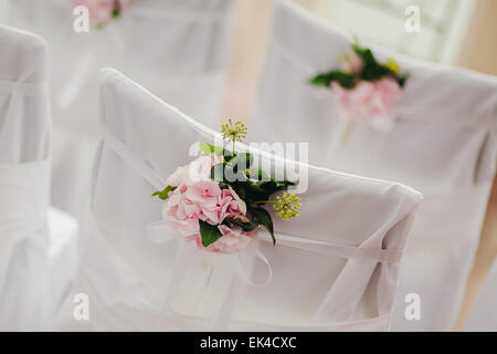 Housse chaise mariage décoration avec des fleurs roses Banque D'Images