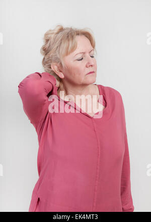 Un vieux blond woman holding son cou avec sa main Banque D'Images