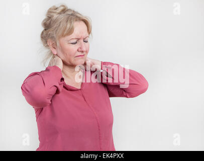 Un vieux blond woman holding son cou avec sa main Banque D'Images