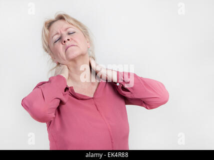 Un vieux blond woman holding son cou avec sa main Banque D'Images