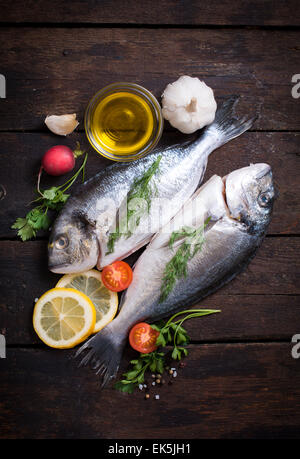 Poisson avec des ingrédients crus dorada sur fond de bois Banque D'Images