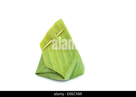 Le riz gluant cuit à la vapeur avec de la crème anglaise, enveloppés dans des feuilles de bananier isolé sur fond blanc Banque D'Images