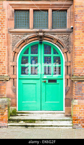 Un livre vert porte en arche dans un bâtiment en briques rouges au Royaume-Uni Banque D'Images