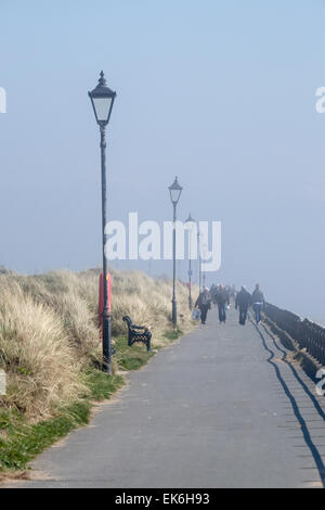 Marcher le long du bord de mer à Lytham-St-Annes comme la brume dans les rouleaux de la mer Banque D'Images