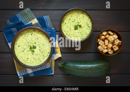 Coup de frais généraux deux bols rustiques de crème de courgettes soupe garnie de feuilles de persil, avec un bol de croûtons maison Banque D'Images