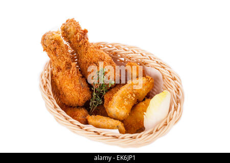 Des cuisses de poulet croustillantes ailes d'or et frits dans la chapelure et servi avec un bol de trempette dans un panier en osier pour un de Banque D'Images