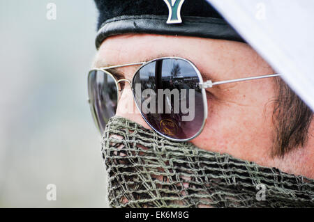 Un homme masqué portant un scrim sur sa bouche, lunettes de soleil et un béret noir fait partie d'une commémoration Républicaine Irlandaise Banque D'Images