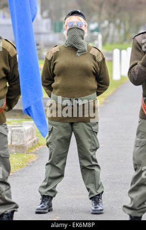 Une femme portant un scrim masqué sur sa bouche, lunettes de soleil et un béret noir fait partie d'une commémoration Républicaine Irlandaise Banque D'Images