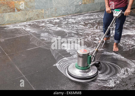 Les thaïlandais avec un sol en granit noir de nettoyage chimique et de la machine Banque D'Images