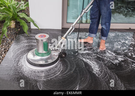 Les thaïlandais avec un sol en granit noir de nettoyage chimique et de la machine Banque D'Images