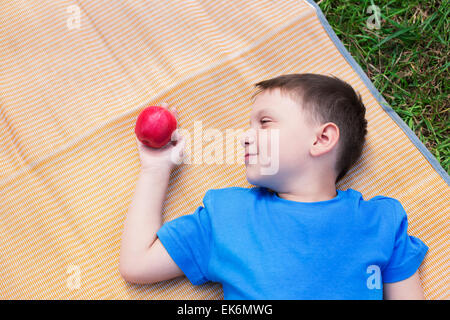 Garçon portant sur mat et regarder red apple Banque D'Images