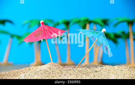 Deux petits parasols sur une plage avec des palmiers Banque D'Images