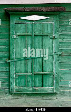 Vieille fenêtre en bois dans un mur painte de couleur verte. Astrakhan, Russie. Banque D'Images